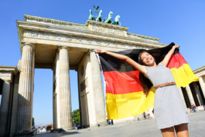Frau mit Deutschlandflagge vor dem Brandenburger Tor